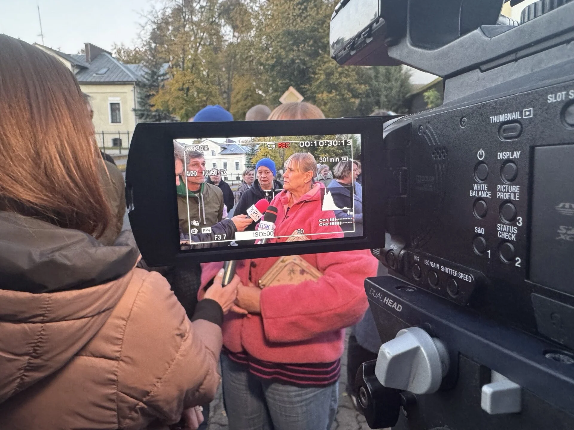 Dziennikarze rozmawiają z mieszkanką przed spotkaniem w Ciechocinku.
