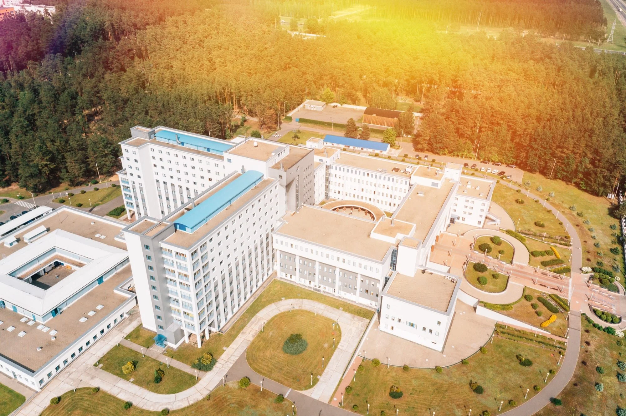 Widok z góry na duży budynek medyczny w otoczeniu lasu.