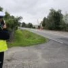 Policjant mierzący prędkość pojazdów przy drodze
